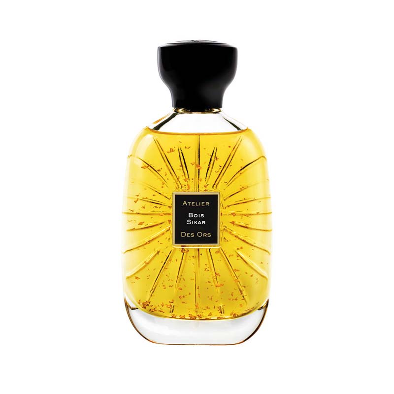 100ml curved glass bottle with yellow liquid and gold flakes, a black label, and a black bulbous cap.