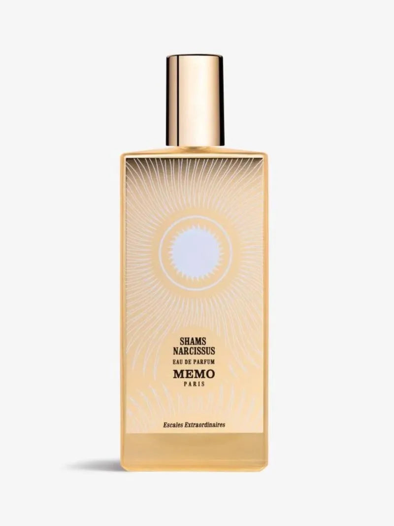 A 75ml rectangular tan-colored bottle of Memo Paris Shams Narcissus Eau de Parfum from France, featuring a sun-patterned gold plate and a tall gold cap.