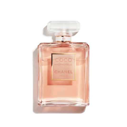 A bottle of COCO Mademoiselle perfume by Chanel with a pink-tinted liquid visible through the clear glass bottle, featuring a white cap and a gold label.