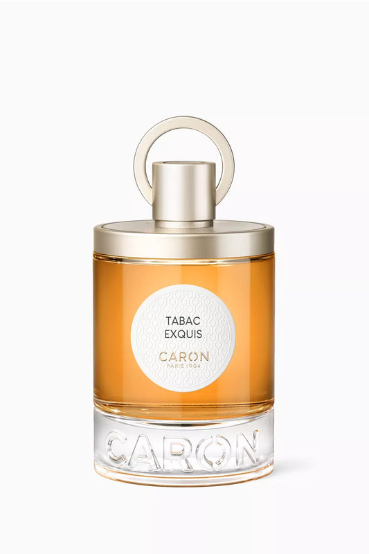 100ml circular glass bottle of Caron Paris Tabac Exquis with a white textured label and gold cap.