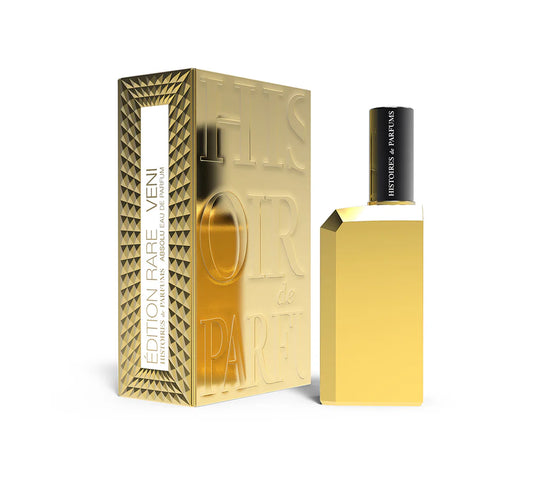 A 60ml sleek gold-toned bottle of Histoires de Parfums Edition Rare Veni Eau de Parfum from France, shown next to its ornate gold and black presentation box.