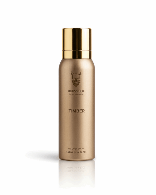 A 100ml matte gold aerosol bottle of Marvalea Timber All Over Spray from the Middle East with a minimalist brown logo and a matching gold cap.